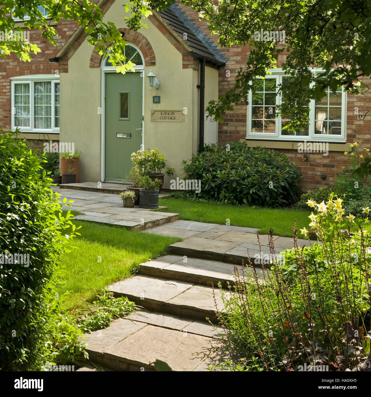 Jolie maison de style chalet moderne avec des marches de pierre et le chemin dans le jardin avant, Leicestershire, Angleterre, Royaume-Uni. Banque D'Images