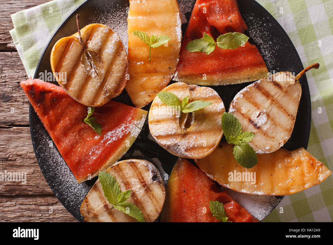 Fruits grillés : pastèque, melon, pomme, poire sur une assiette macro. Vue du dessus horizontale Banque D'Images