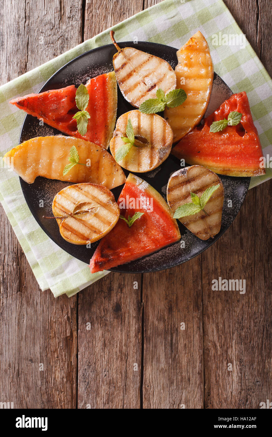 Pastèque, melon, poire, pomme et grillades de close-up sur une assiette. vertical Vue de dessus Banque D'Images