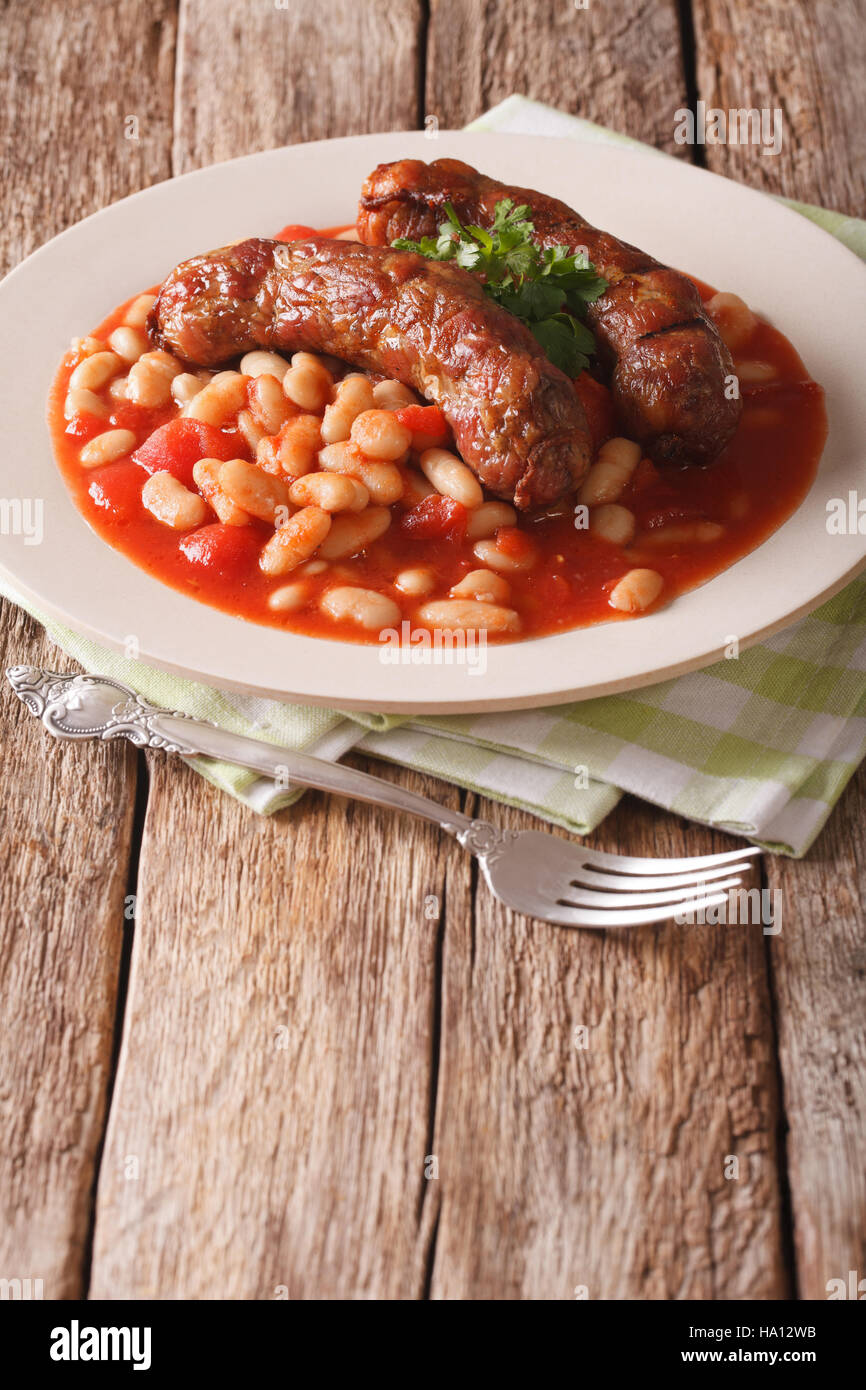 Les haricots avec saucisses grillées, européenne traditionnelle repas fait maison sur une assiette sur la table. vertical Banque D'Images