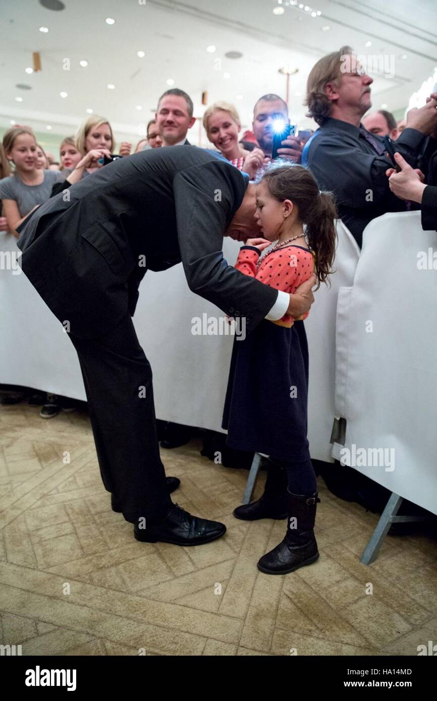 Le président des États-Unis, Barack Obama, se penche pour entendre un message personnel d'une jeune fille au cours de l'ambassade des États-Unis l'accueil à l'hôtel Adlon, 16 novembre 2016 à Berlin, Allemagne. Banque D'Images