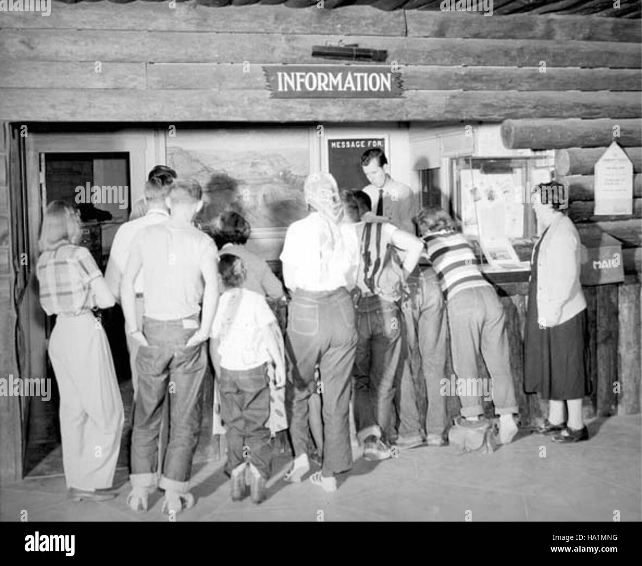 Cette image historique de 1951 montre les visiteurs du parc national du Grand Canyon rassemblés au bureau d'information. Il souligne les débuts du tourisme dans le parc et l'engagement du public dans les efforts éducatifs du service du parc. Banque D'Images