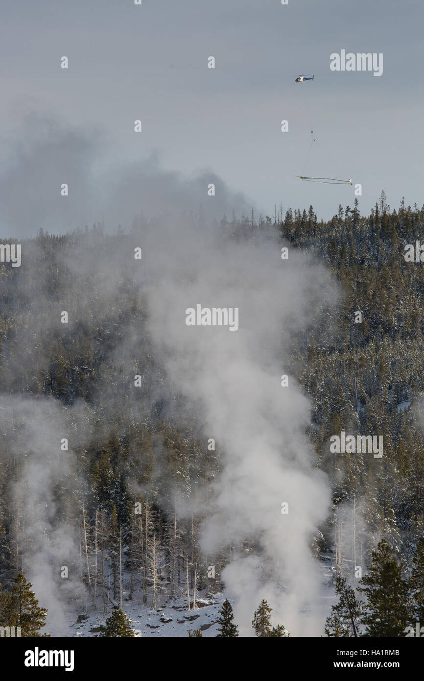 Un hélicoptère effectue un levé souterrain près du Upper Geyser Basin dans le parc national de Yellowstone. L'enquête vise à recueillir des données sur l'activité géothermique et les systèmes d'eau souterraine qui contribuent aux caractéristiques géothermiques uniques du parc. Banque D'Images