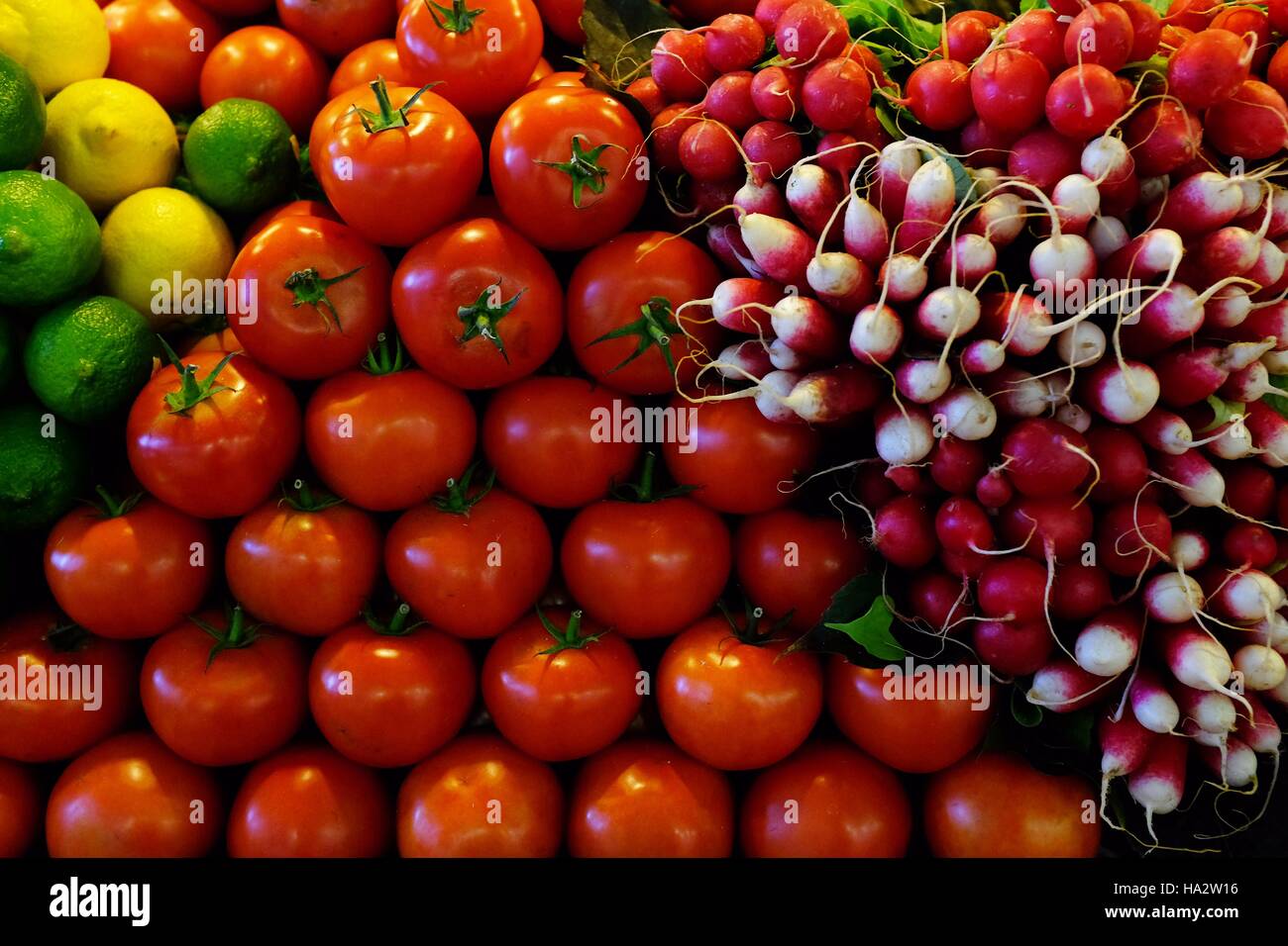 Close-up de radis, les tomates, le citron et la lime sur un étal du marché Banque D'Images