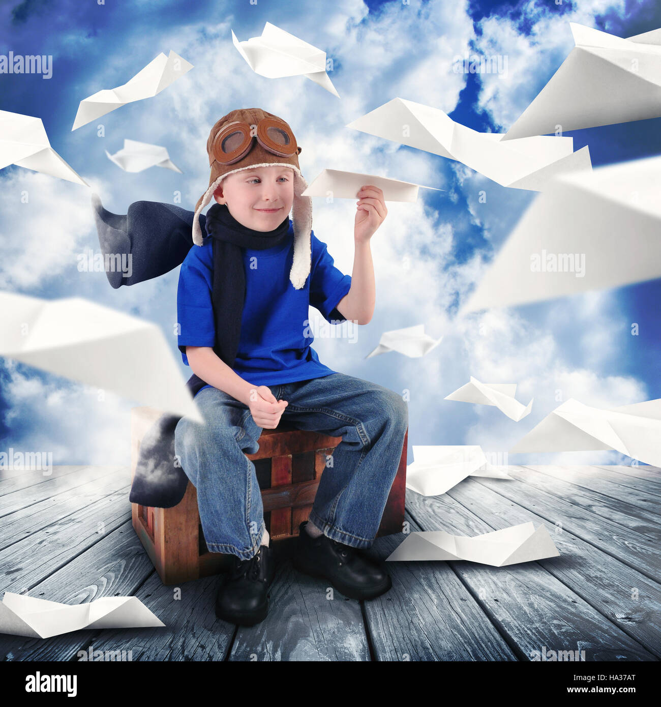 Un petit enfant est maintenant un avion en papier dans le ciel vous rêvez d'être un pilote aux commandes. Le garçon est heureux pour une carrière ou dream concept. Banque D'Images