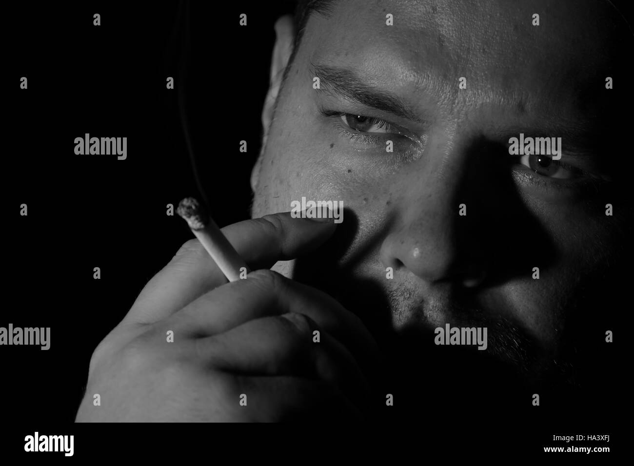 Jeune homme cigarette monochome Banque D'Images