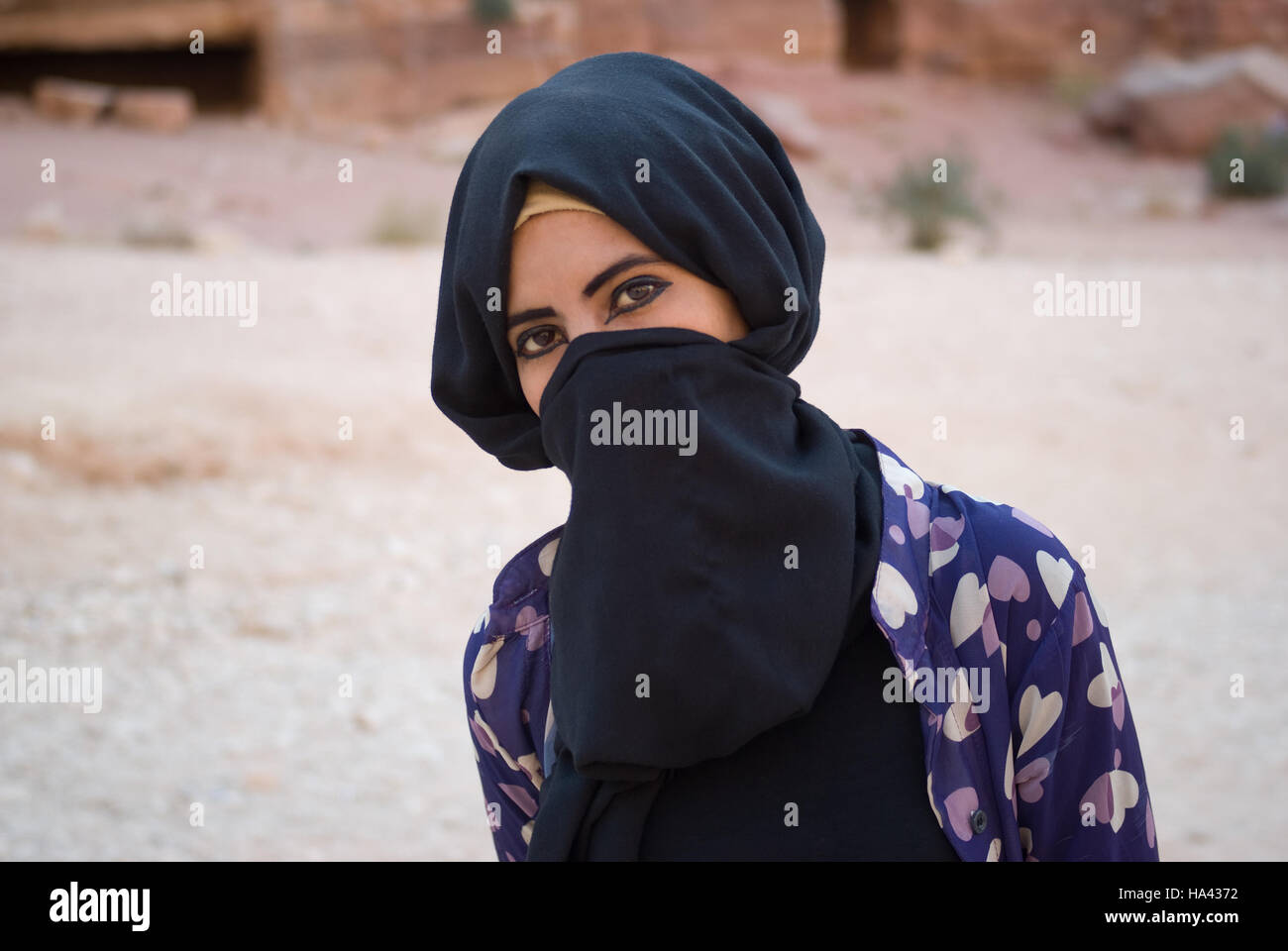 Gros plan d'une jeune fille bédouine avec face cachée derrière le voile posing at camera Banque D'Images