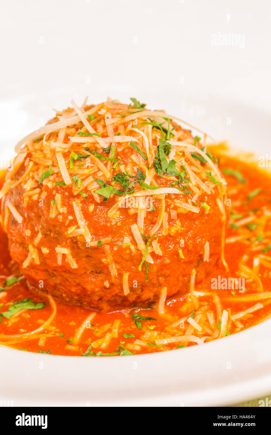 Un très grand Italian meatball baigné dans de riches pomodoro, garni de persil et de parmesan Banque D'Images