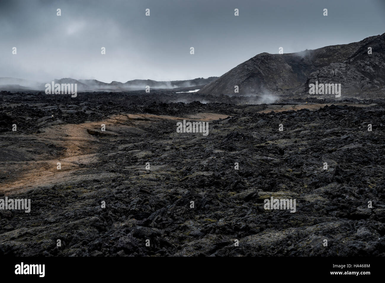 Chemin lumineux à travers le champ de lave de fumer noir en Islande Banque D'Images