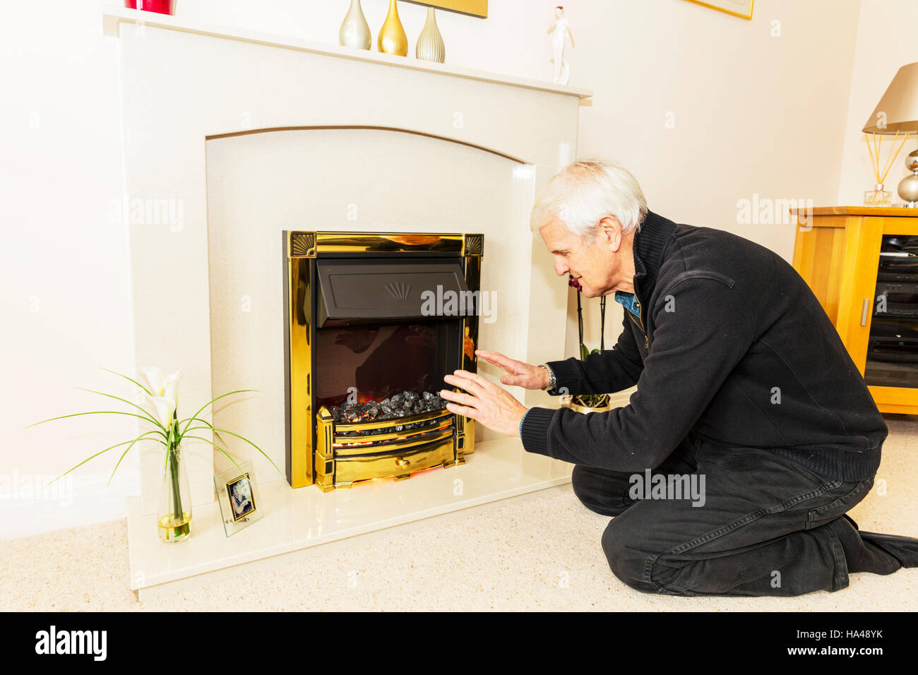 Dao en essayant de garder au chaud les mains de réchauffement près d'un feu en gardant les factures de chauffage ne peut pas se permettre les factures d'énergie de gaz haute chaleur chaleur pensionné dans la pauvreté Banque D'Images