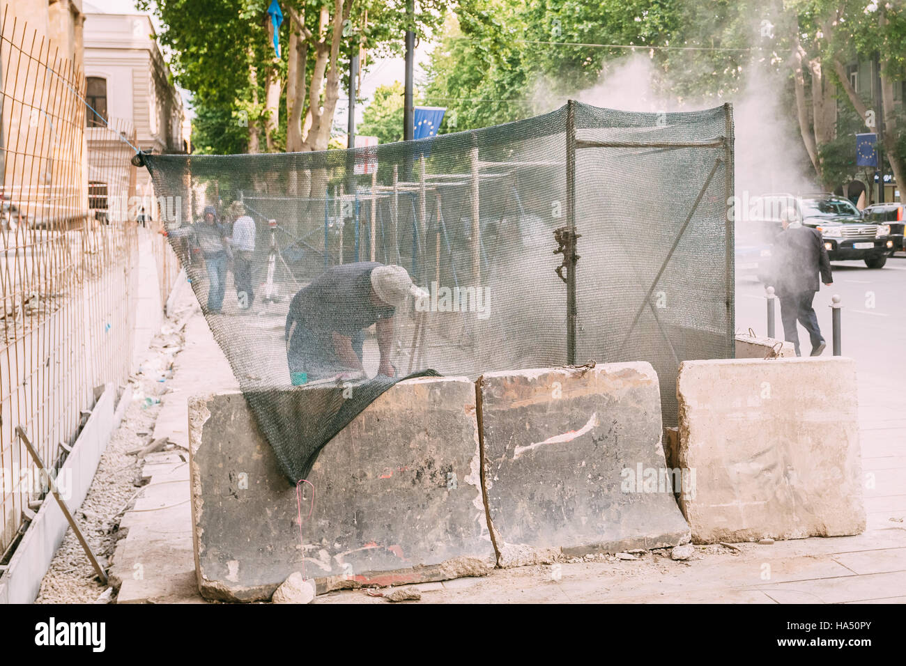 Tbilissi, Géorgie - 20 mai 2016 : Les travailleurs de la réparation Les Trottoirs derrière le boîtier sur l'Avenue Rustaveli au printemps Journée d'été. Banque D'Images