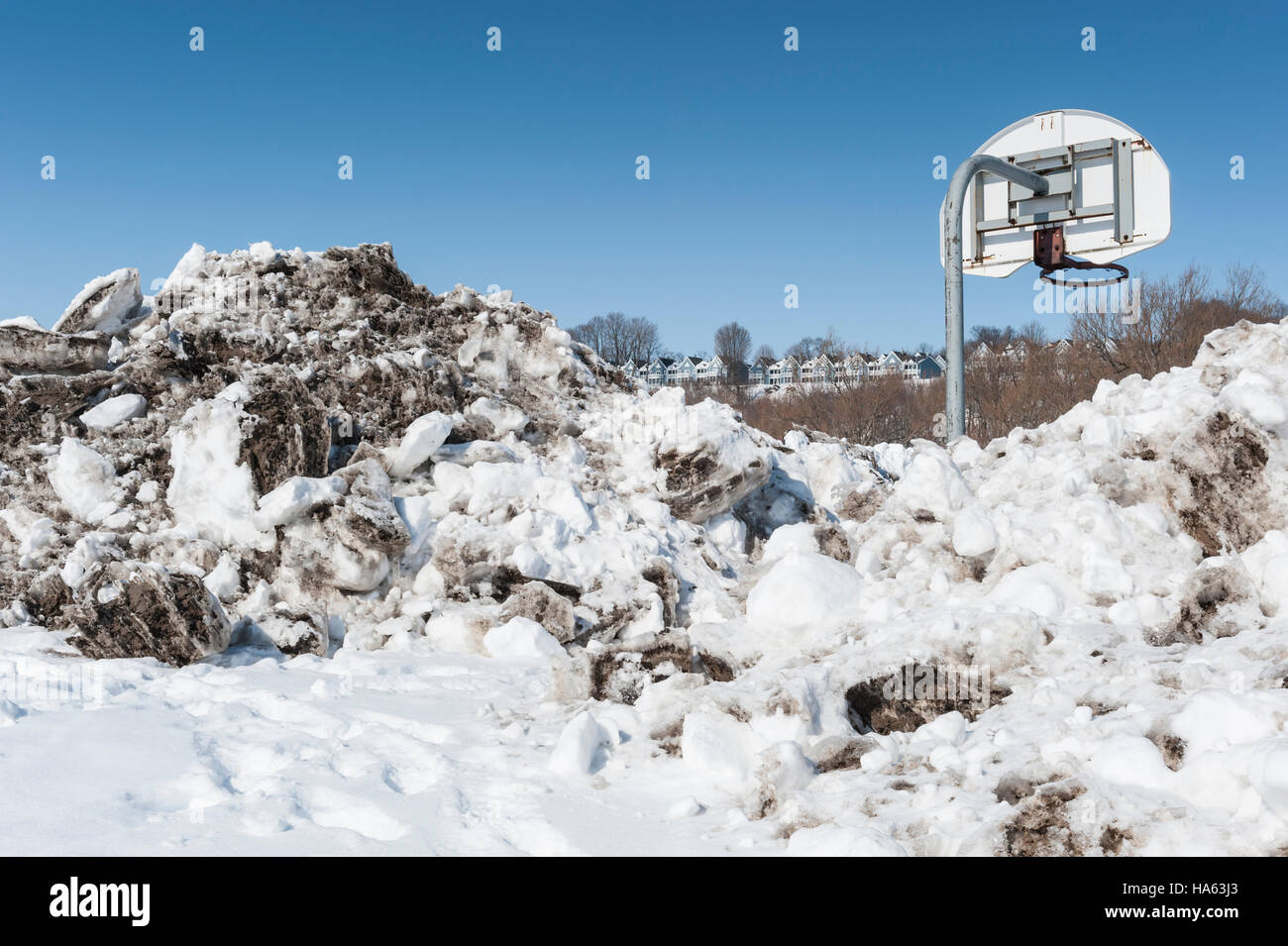Port Stanley, en Ontario, Canada - Un filet de basket-ball entouré par la neige avec la pelle à l'arrière-plan bleu cottages Banque D'Images