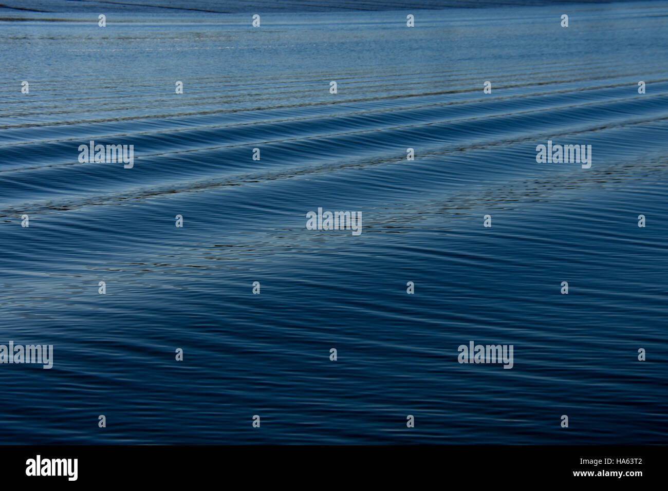 Voile service créer un motif intéressant de vagues sur l'eau ridée bleu. Banque D'Images