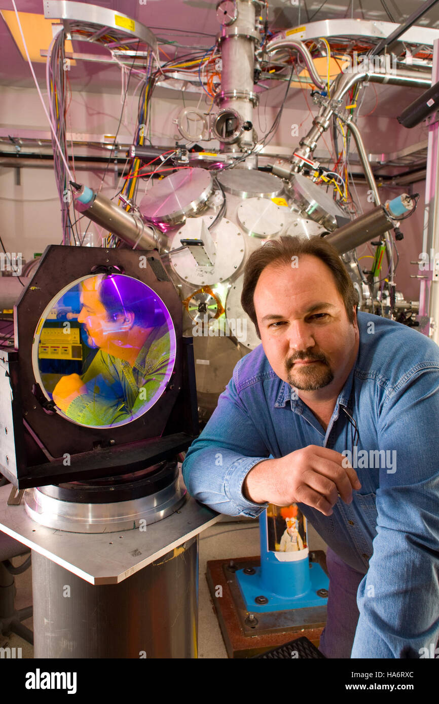 Cette image montre le directeur de Trident, une partie du laboratoire national de Los Alamos, reflété dans les miroirs de haute technologie avancés de l'installation. La photographie capture l'intersection de la science, de la technologie et du leadership dans un cadre de recherche moderne. Banque D'Images