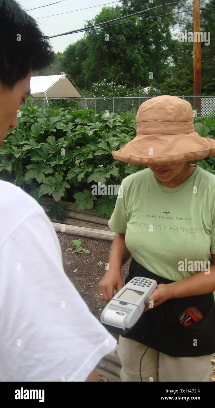 Le personnel de Windy City Harvest exploite la machine EBT (Electronic Benefit Transfer) au People's Garden dans le Midwest, aidant à distribuer de la nourriture et à aider les membres de la communauté dans le besoin. Banque D'Images