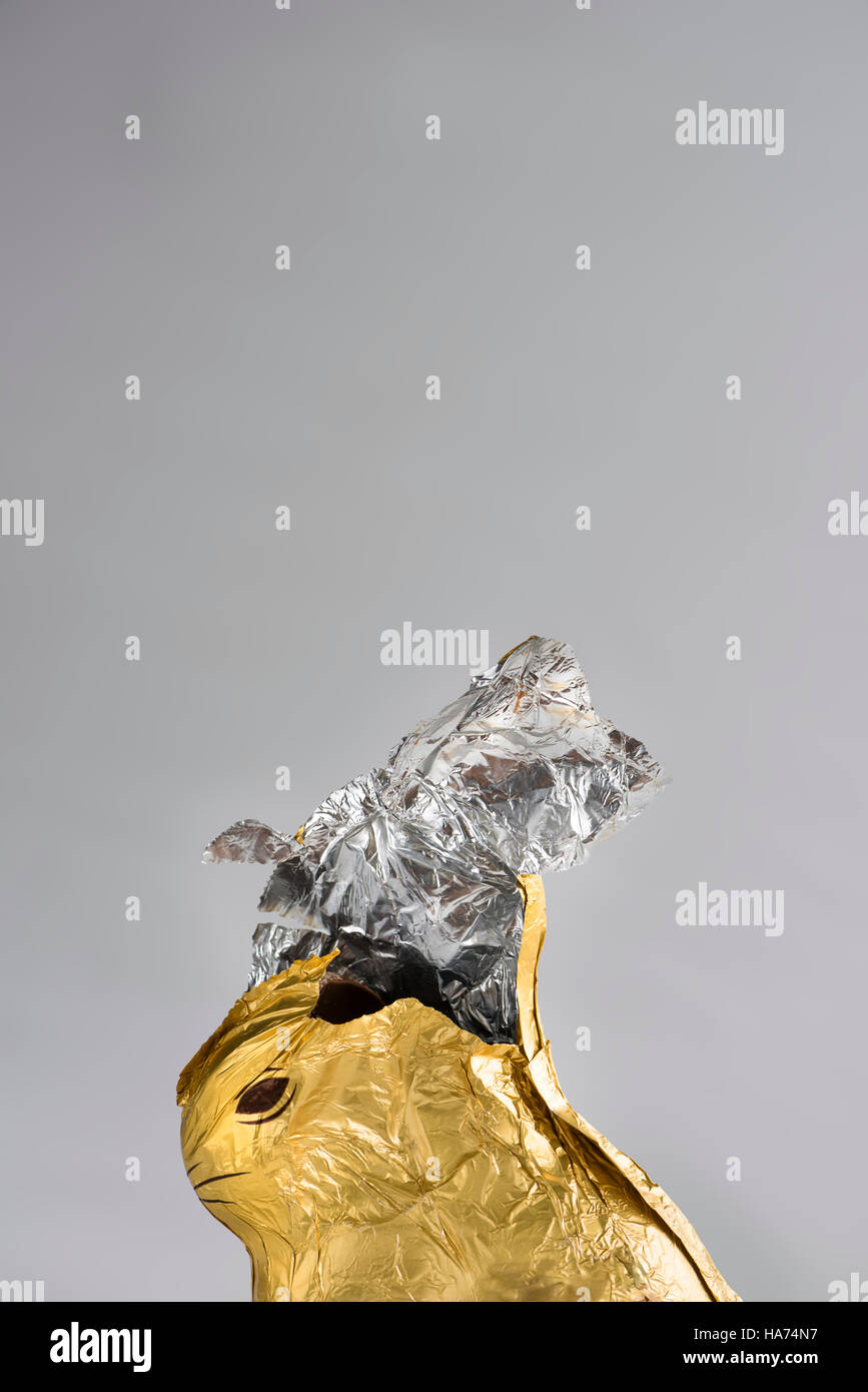 Lapin de Pâques au chocolat, enveloppés dans de brillant or et argent, d'aluminium, aluminium partiellement rongée peu à éventrer en haut Banque D'Images