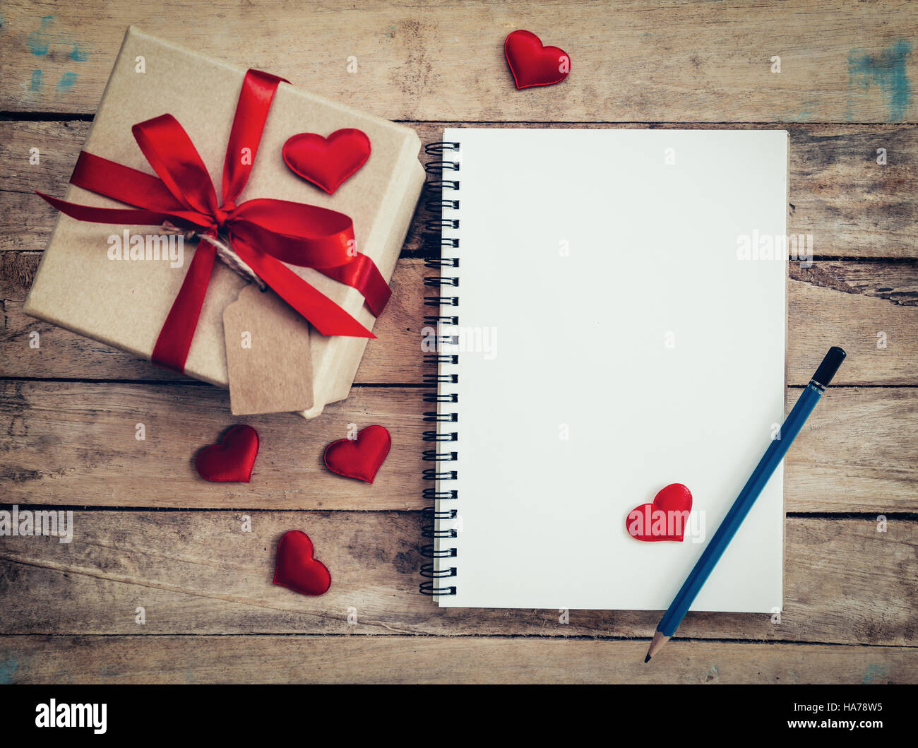 Vue de dessus (ci-dessus) boîte cadeau et ruban rouge et coeur rouge pour la saint valentin avec un ordinateur portable sur la table en bois. Valentine. Banque D'Images
