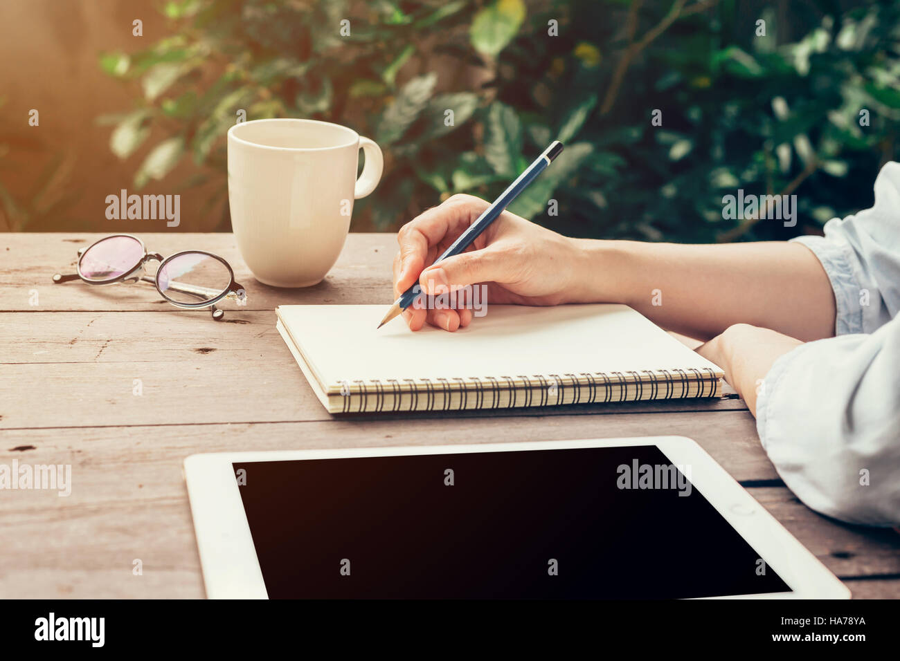 Jeune femme d'affaires la main avec crayon écrivant sur ordinateur portable. Femme part avec crayon écrivant sur un ordinateur portable et travailler au café. Banque D'Images