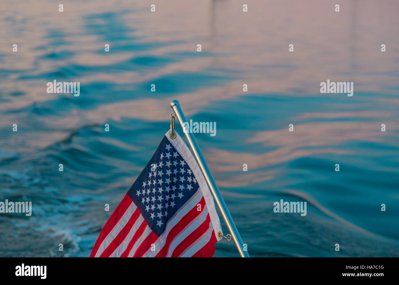 Détail de l'image d'un drapeau américain sur un poteau en acier inoxydable avec de l'eau salée en arrière-plan Banque D'Images