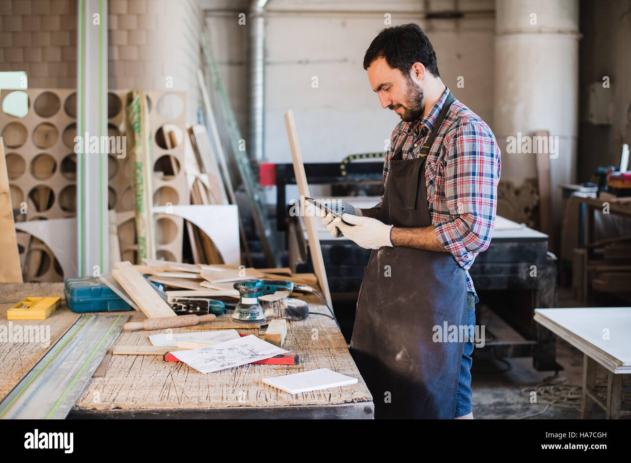 Portrait d'un charpentier bois debout dans son studio et holding digital tablet Banque D'Images