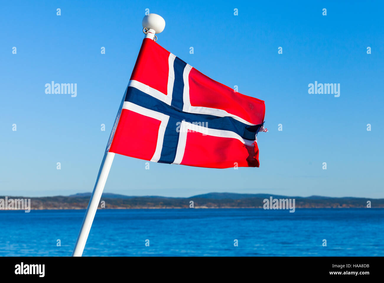Pavillon de la Norvège au-dessus de la mer et fond de ciel bleu Banque D'Images
