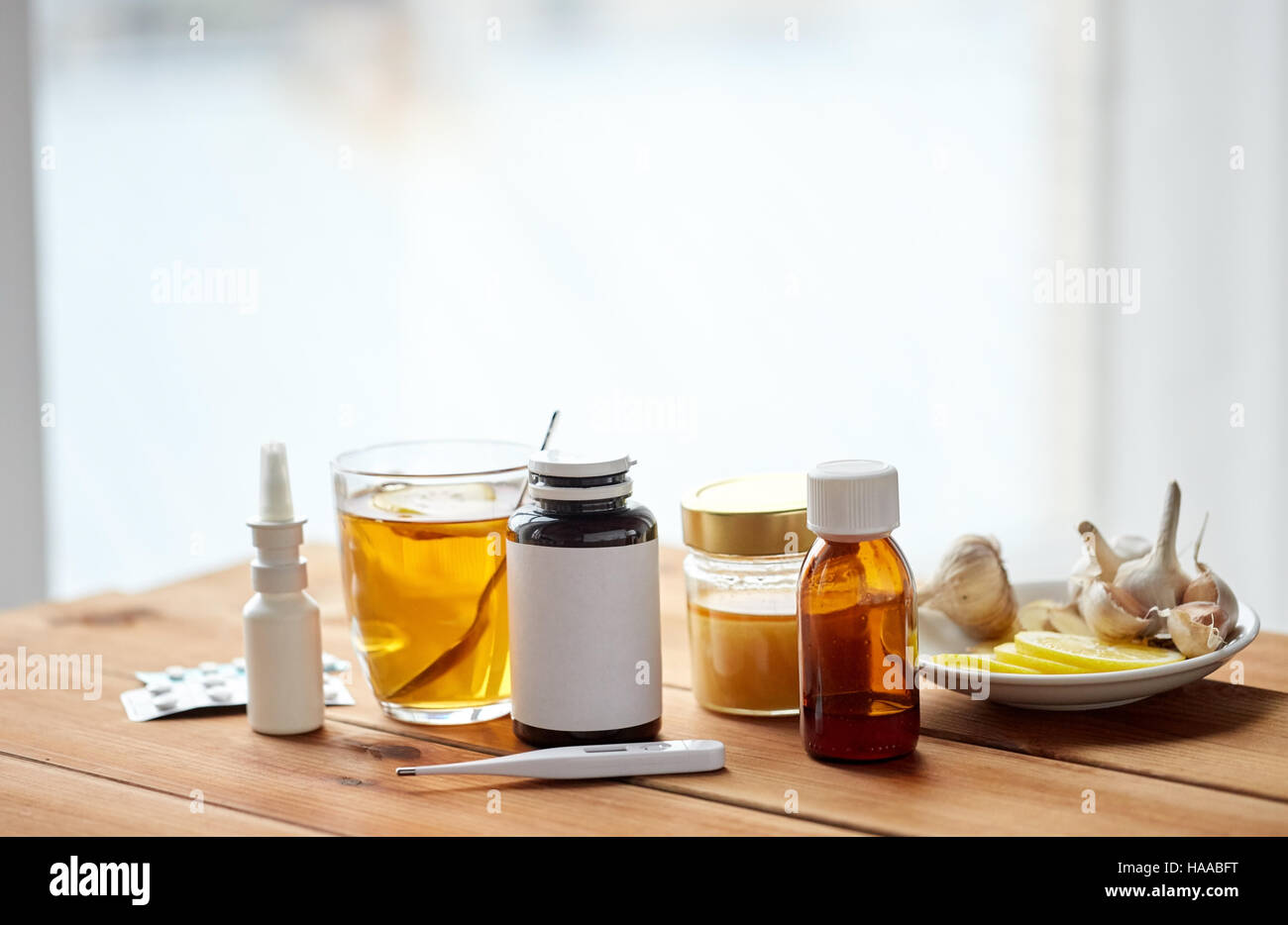 La drogue, thermomètre, le miel et une tasse de thé sur bois Banque D'Images