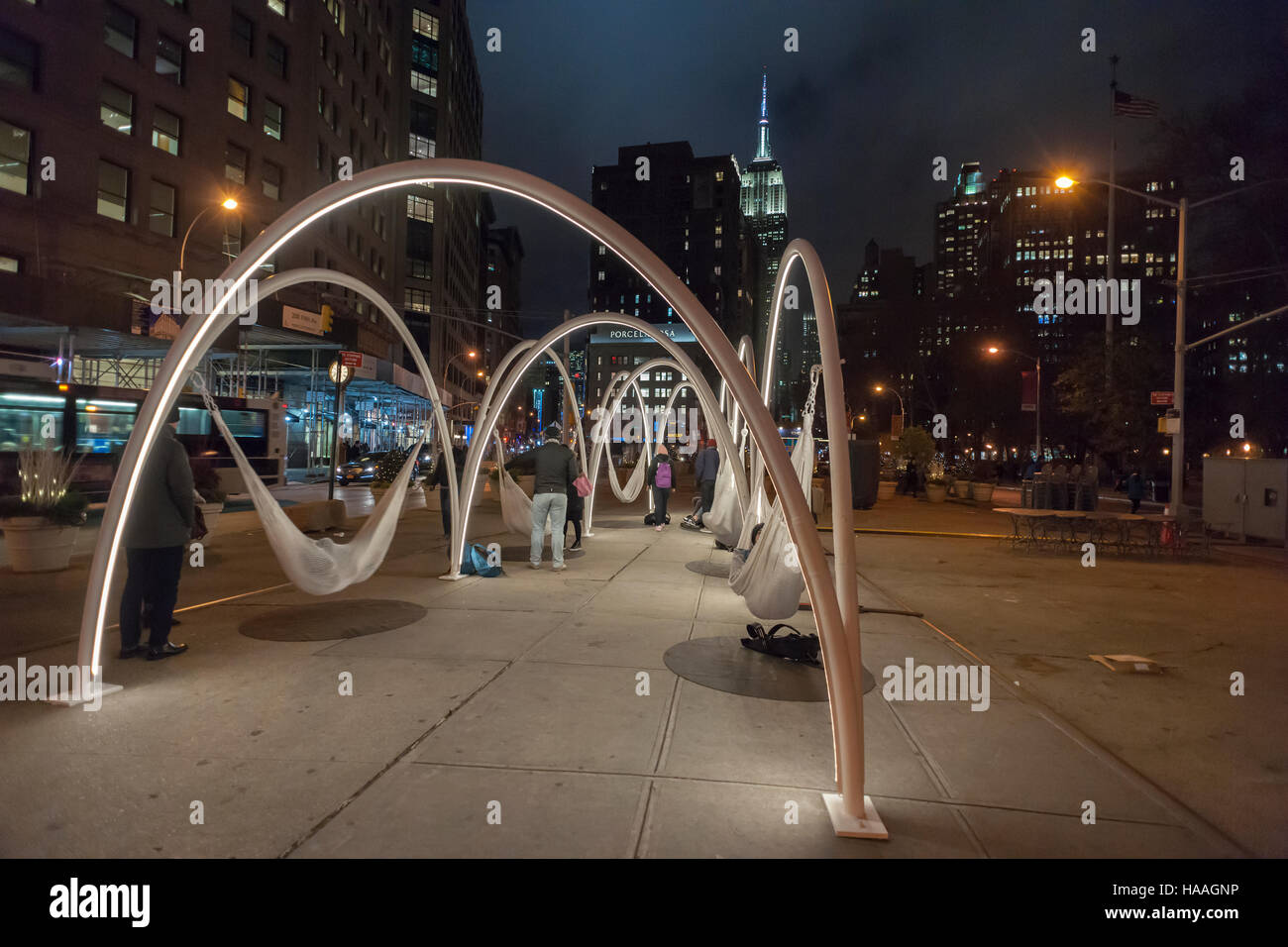 Les visiteurs de Flatiron Plaza à New York le Mardi, Novembre 22, 2016 'interagir avec Sky-Line Flatiron' créé par beaucoup d'architectes. L'installation de Noël est l'élément central de la 23e Rue du Flatiron Partenariat maison de la programmation. Les dix arcs lumineux avec des hamacs suspendus sous impliquer les visiteurs de se détendre et de contempler les merveilles architecturales du quartier, en particulier le Flatiron Building. (© Richard B. Levine) Banque D'Images