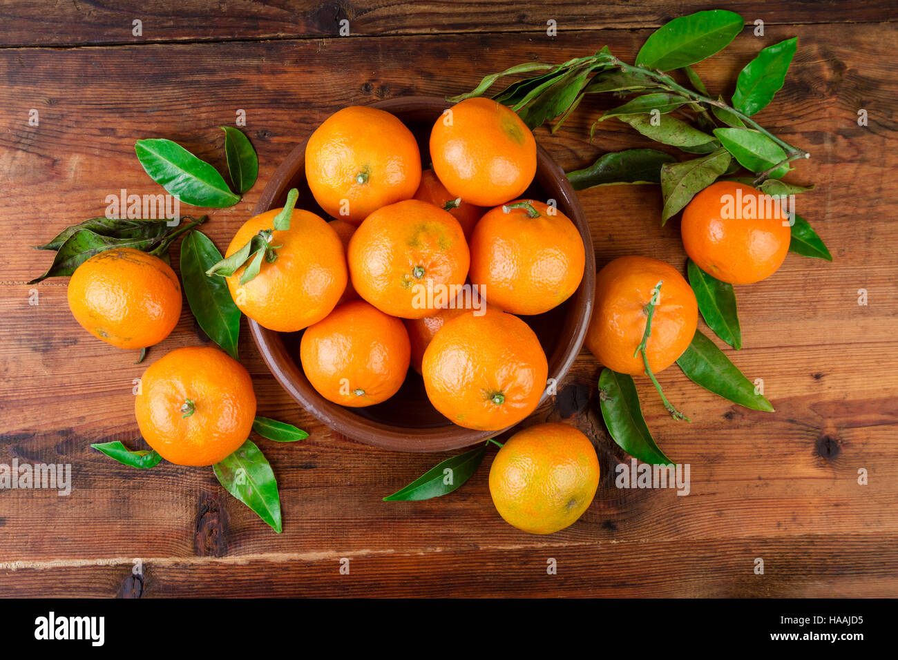 Mandarines mandarines dans un bol en céramique sur table en bois. Vue d'en haut. Banque D'Images