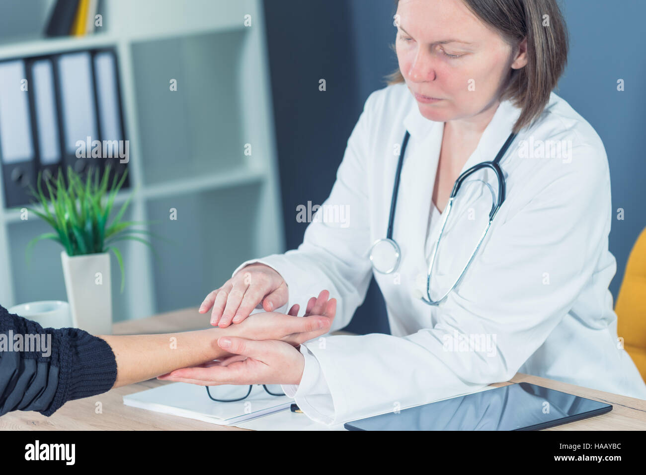 Patient de sexe féminin à l'examen médical en orthopédie de l'hôpital de médecin office, la traumatologie et la consultation médicale pour la blessure au poignet main Banque D'Images