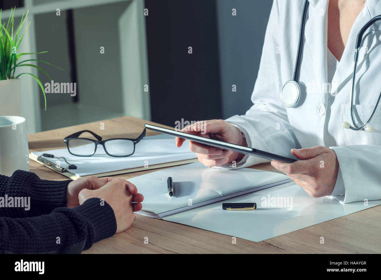 Femme médecin présentant les résultats de l'examen médical du patient à l'aide de digital tablet computer in office hôpital Banque D'Images