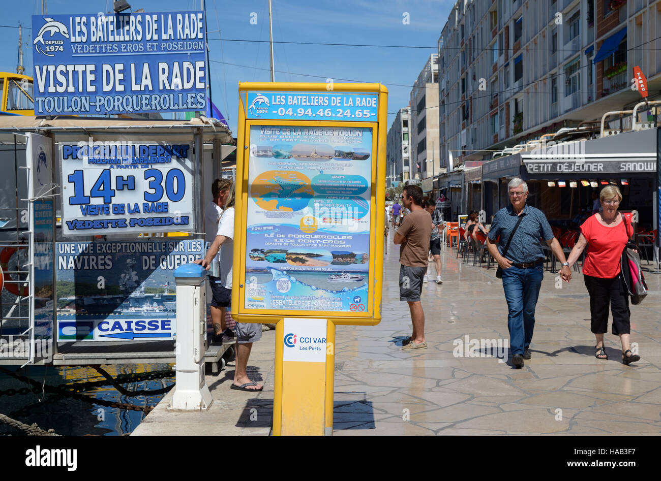 Les touristes d'âge moyen à marcher le long des quais du cours des cafés et des signes de la publicité des excursions en bateau dans la Baie et Port de Toulon Provence France Banque D'Images