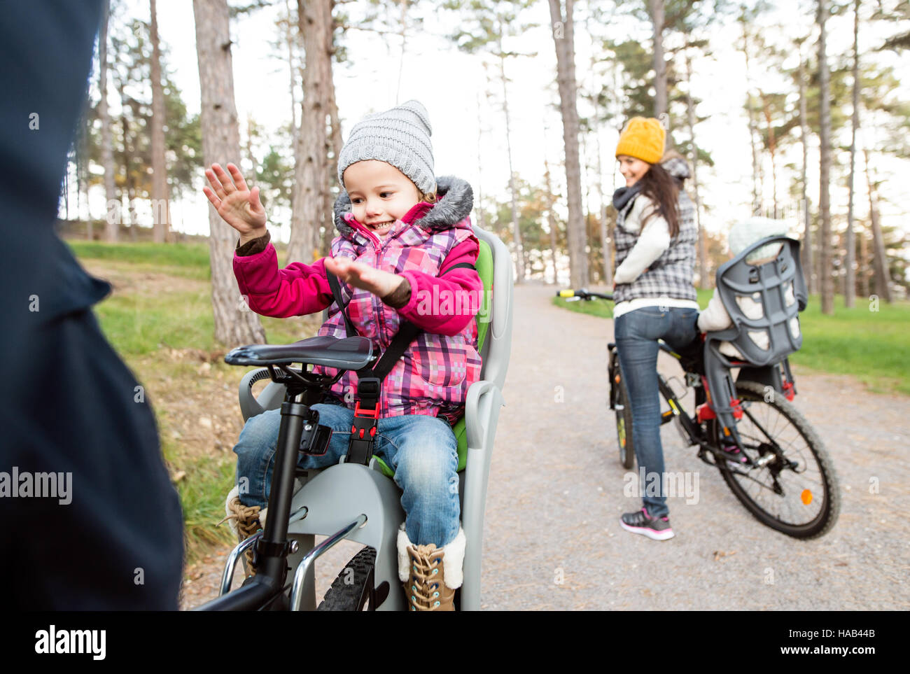 Jeune famille de vêtements chauds à vélo dans le parc en automne Banque D'Images