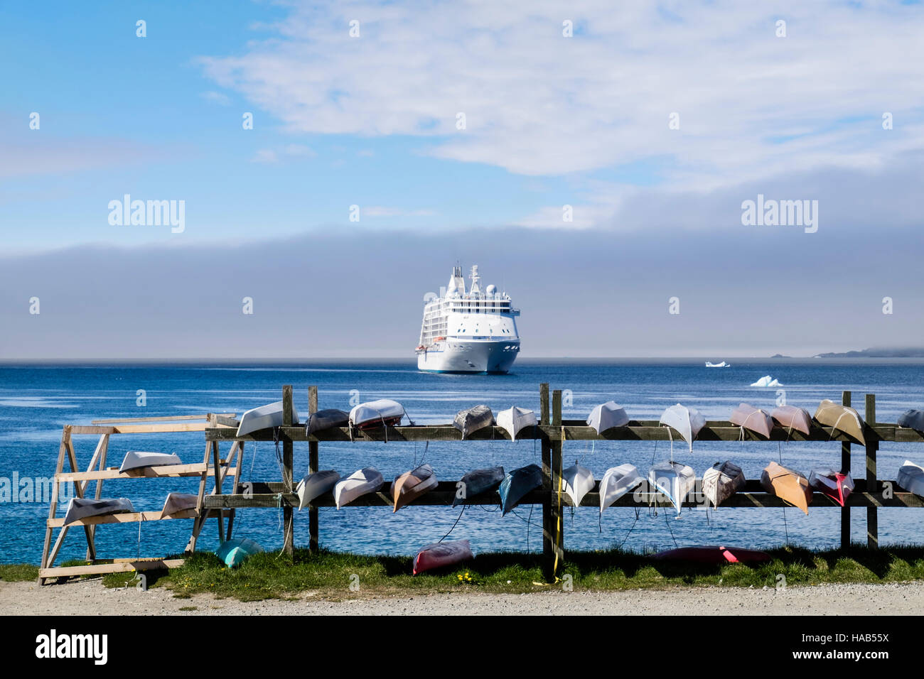 Kayaks inuit traditionnel à l'envers sur une grille par la côte de l'océan avec un paquebot de croisière Seven Seas Voyager amarré au large. Colony Harbour (Kolonihavnen), Banque D'Images