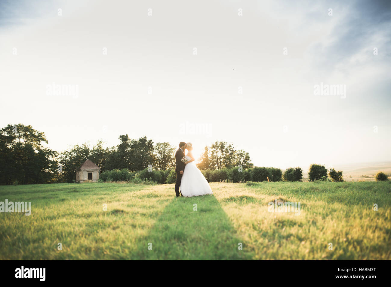 Couple de jeunes mariés heureux élégante promenade dans le parc le jour de leur mariage avec bouquet Banque D'Images