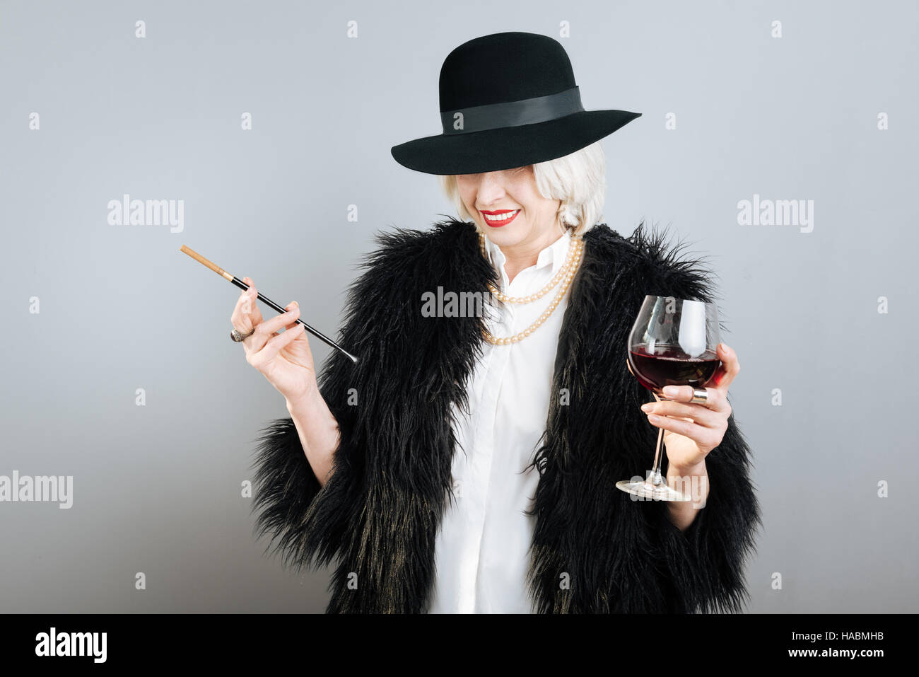 Belle Dame Smiling holding cigarette et verre. Banque D'Images