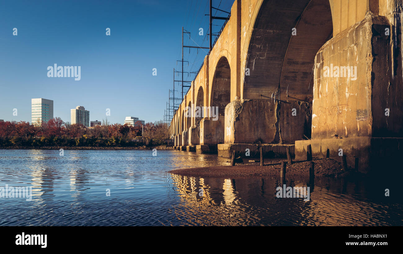 S'étendant sur les rives de la par Raritan, New Brunswick, NJ, le corridor nord-est de la ligne ferroviaire est situé au sommet d'un pont de chemin de fer. Banque D'Images