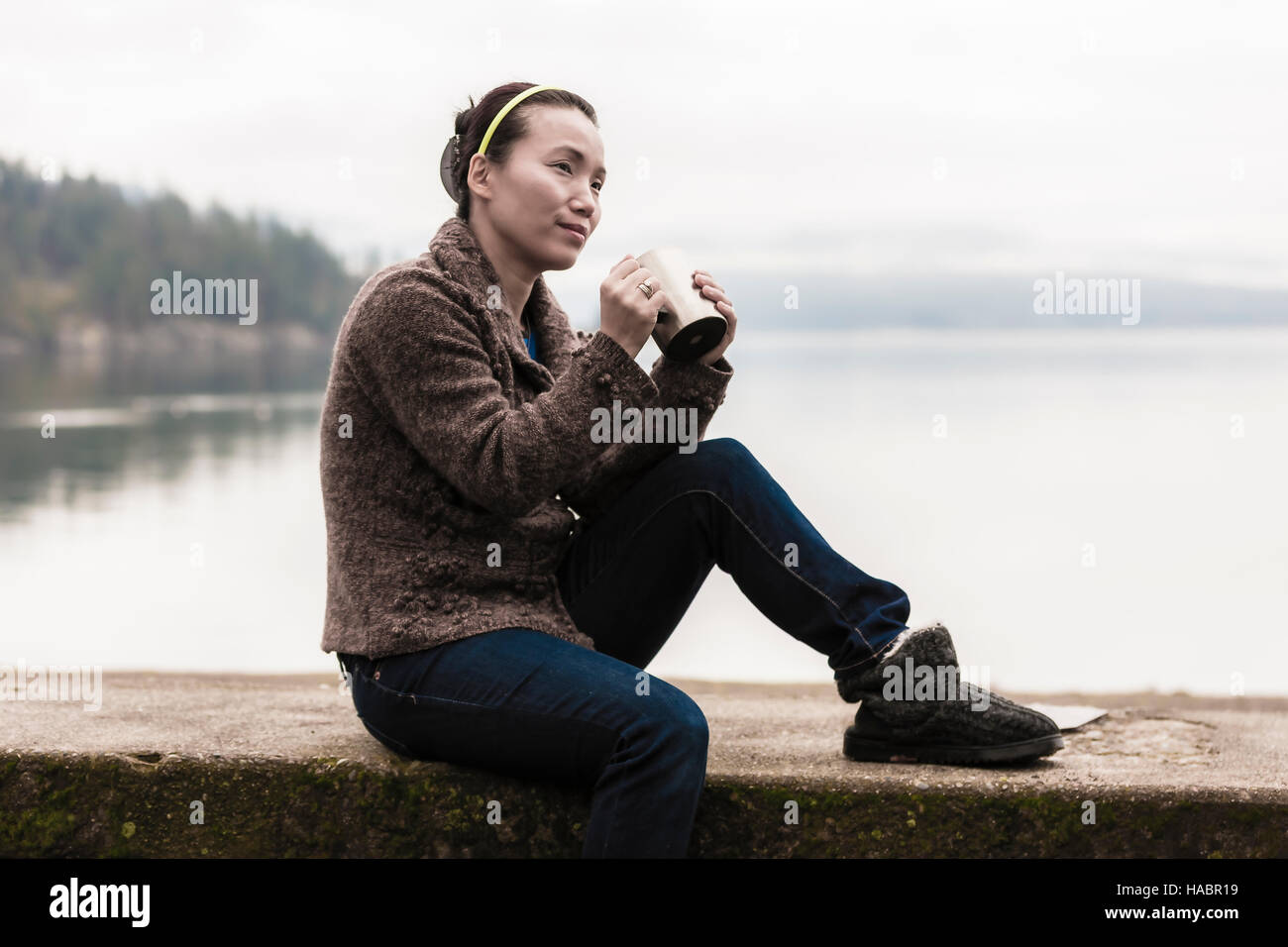 Femme avec du café par le lac. Banque D'Images Femme avec du café par le lac. Banque D'Images