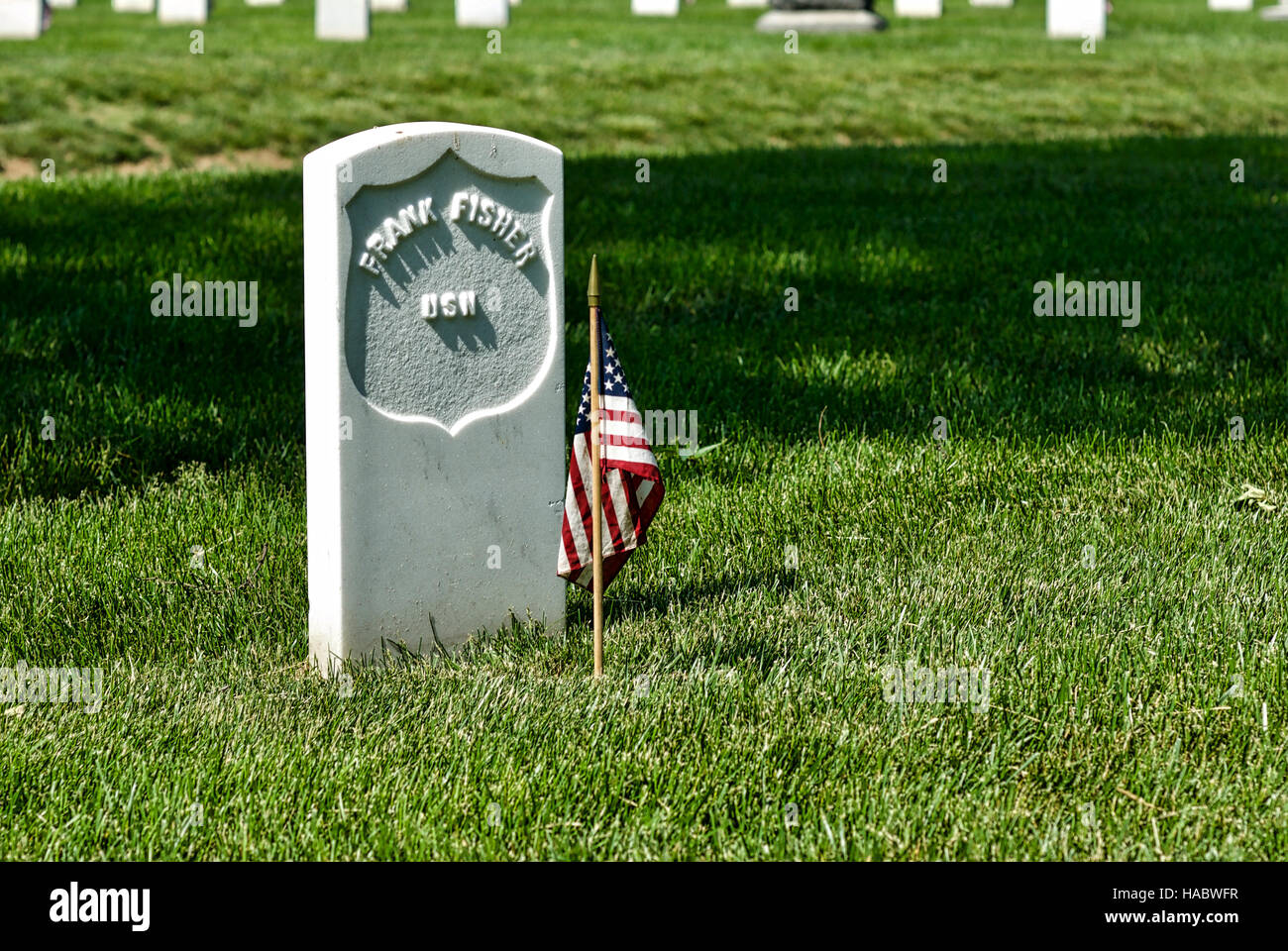 Libre d'une pierre tombale avec un drapeau américain au cimetière national d'Arlington, Arlington, Virginia, USA, le week-end du Memorial Day. Banque D'Images