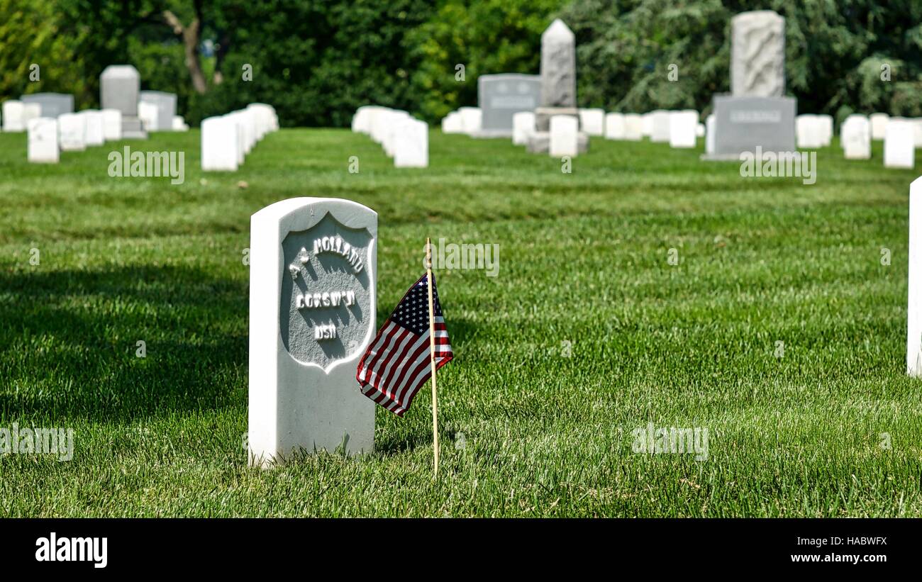 Pierre tombale isolé avec le drapeau américain au cimetière national d'Arlington, Virginie, USA, le week-end du Memorial Day. Banque D'Images