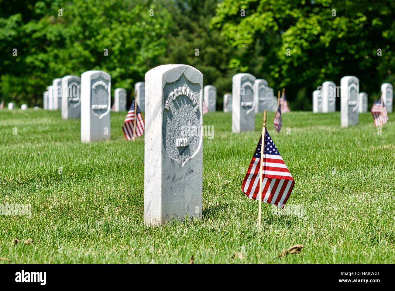 Pierres tombales avec le drapeau américain au cimetière national d'Arlington, à Fort Myer, Arlington, Virginia, USA, le week-end du Memorial Day. Banque D'Images