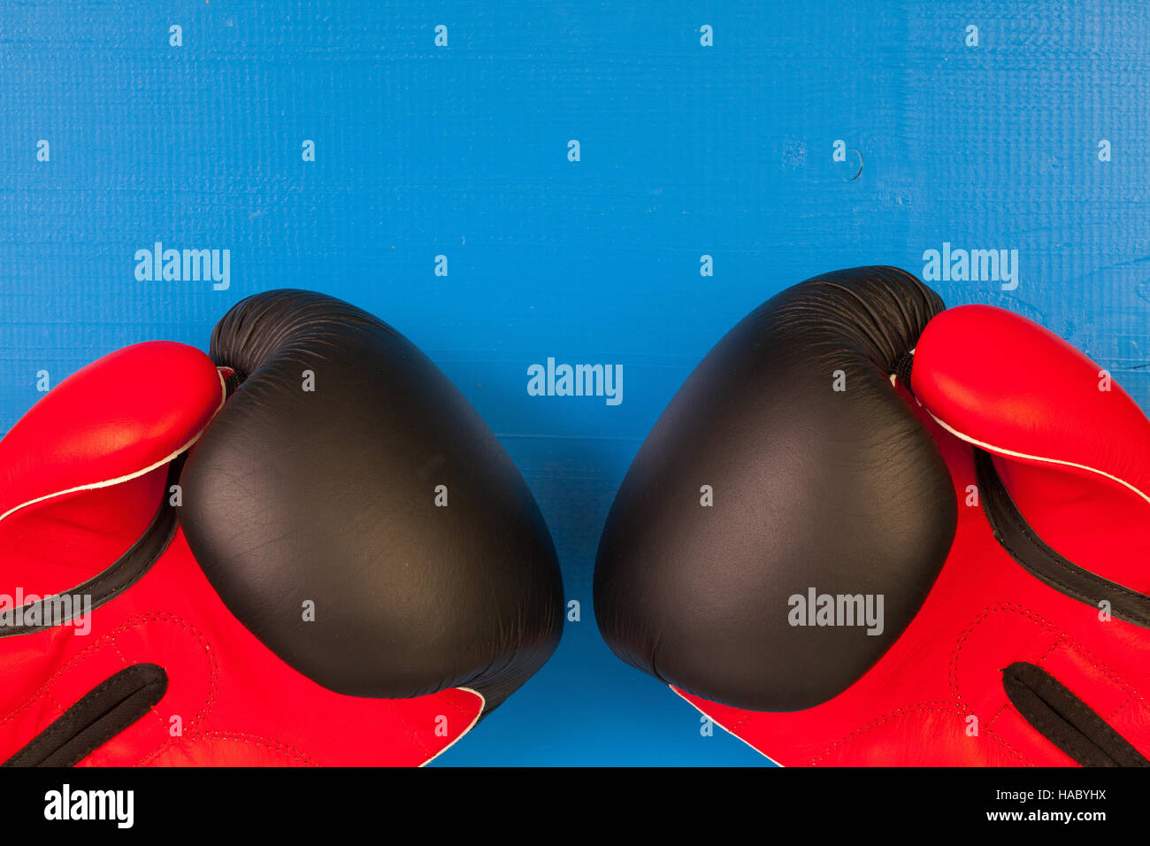 Gants de boxe rouge et noir sur un bureau en bois bleu Banque D'Images