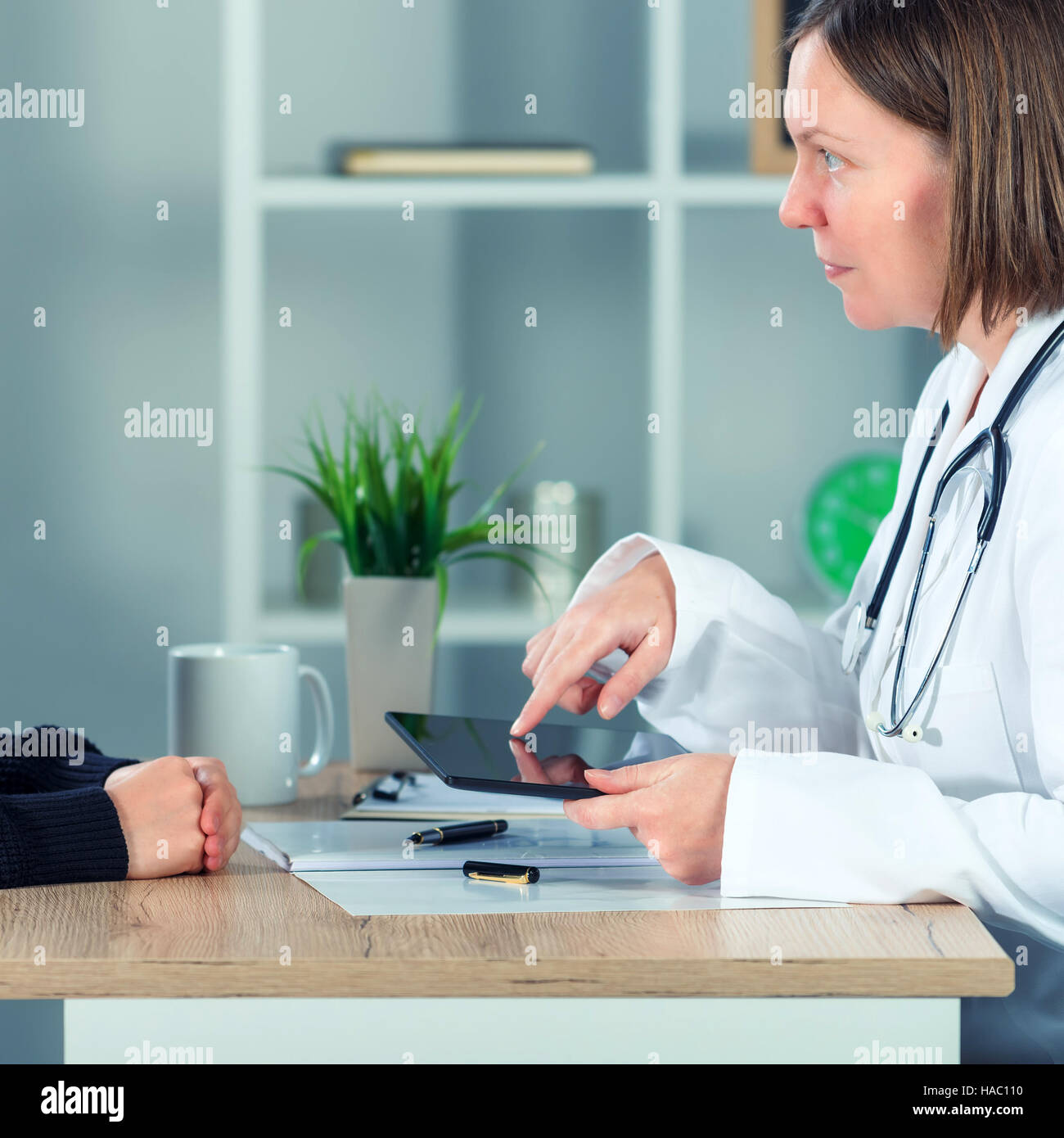 Femme médecin présentant les résultats de l'examen médical du patient à l'aide de digital tablet computer in office hôpital Banque D'Images