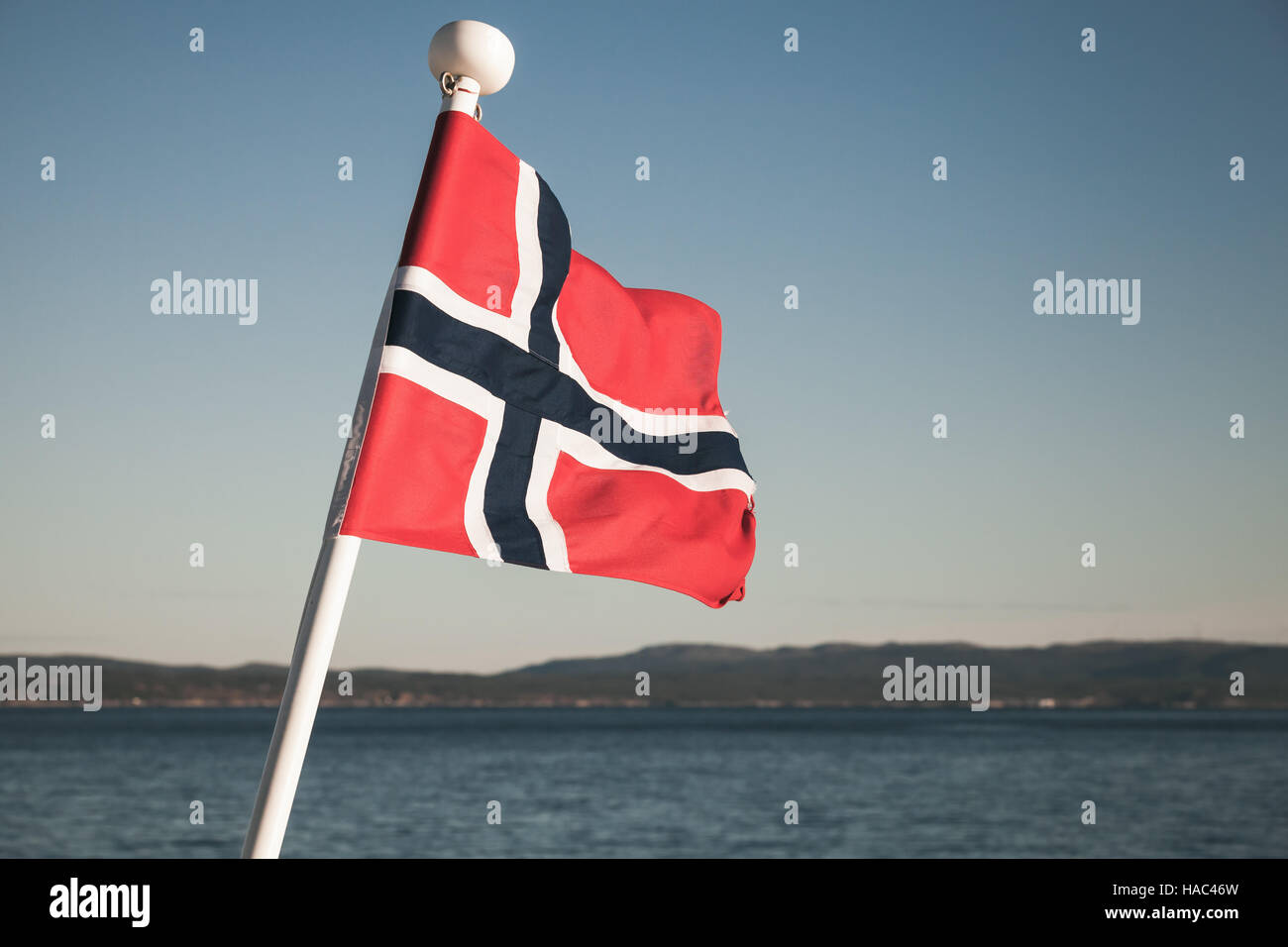 De brandir le drapeau national norvégien sur fond de ciel bleu, vintage photo aux tons Banque D'Images