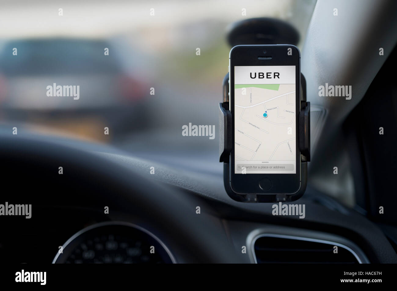 L'intérieur d'un Uber taxi avec un iPhone sur le pare-brise de la voiture avec le logo de l'entreprise. Banque D'Images