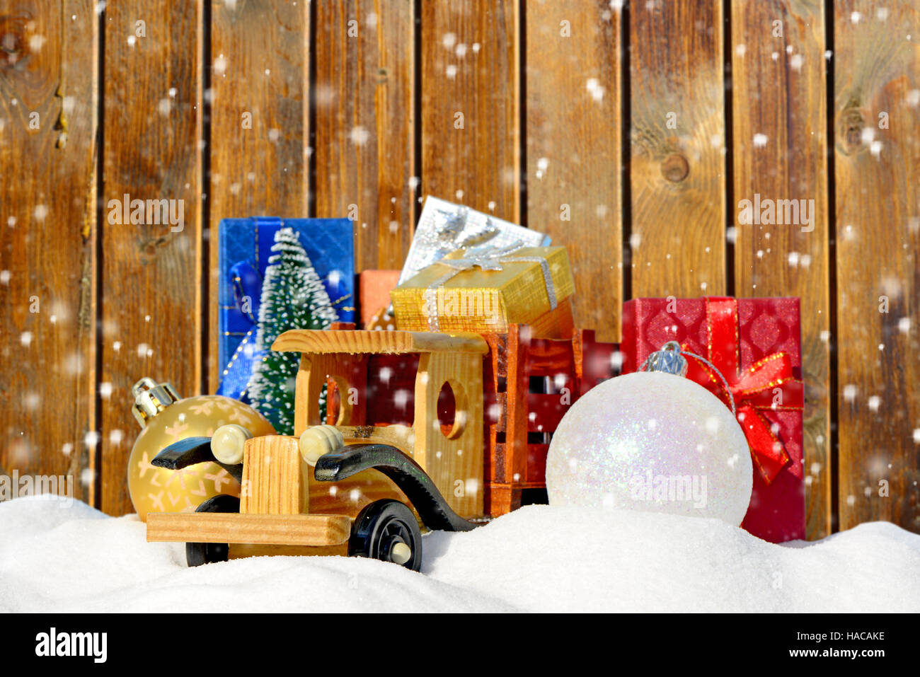 Camion jouet avec les cadeaux, le sapin et boules à la nouvelle année dans la neige Banque D'Images