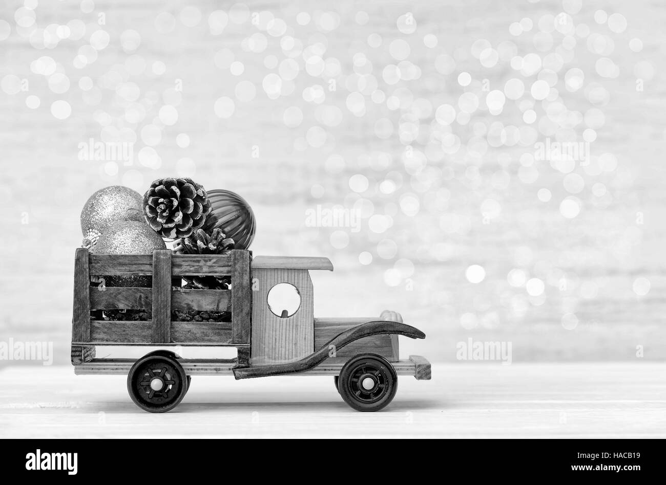 Petite voiture avec les jouets de Noël sur un fond blanc en bois Banque D'Images
