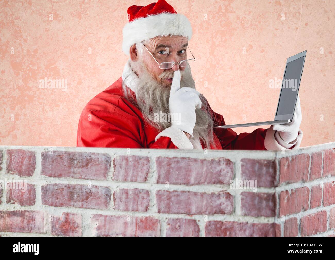 Père Noël avec le doigt sur les lèvres a laptop Banque D'Images