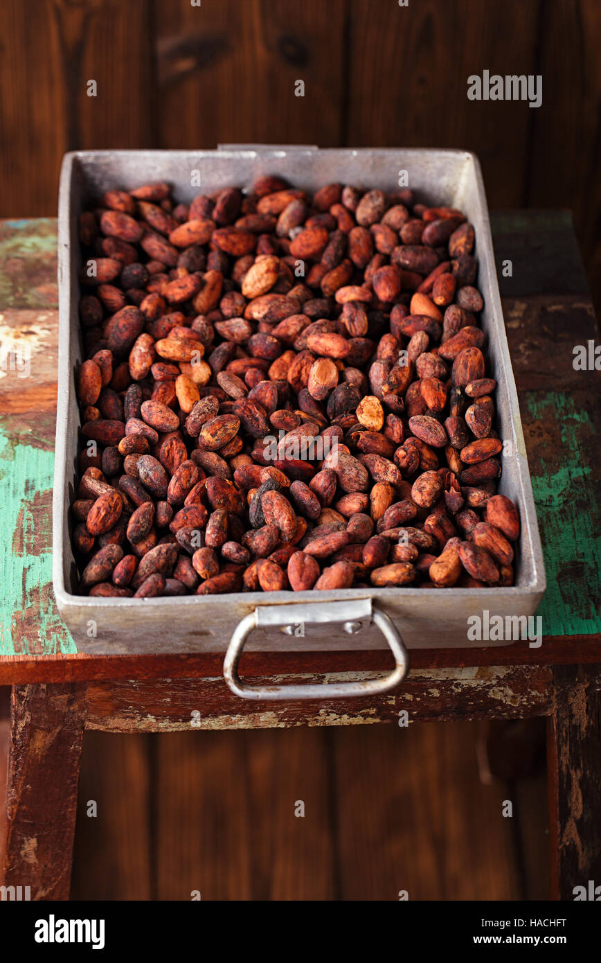 Chocolat Cacao rôti haricots en fonte d'aluminium lourd Vintage rôtissoire sur fond de bois Banque D'Images