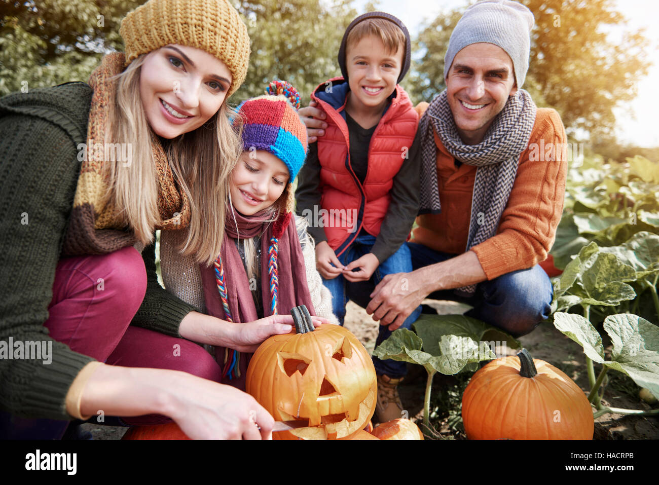 Belle famille travaillant sur les citrouilles Halloween Banque D'Images