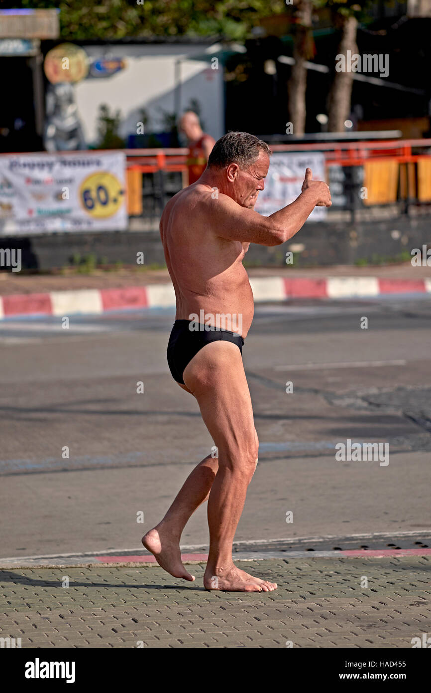 Habillé de façon inappropriée caucasien homme portant des Speedos maillot de bain dans la rue. S. E. Asia Pattaya Thaïlande Banque D'Images